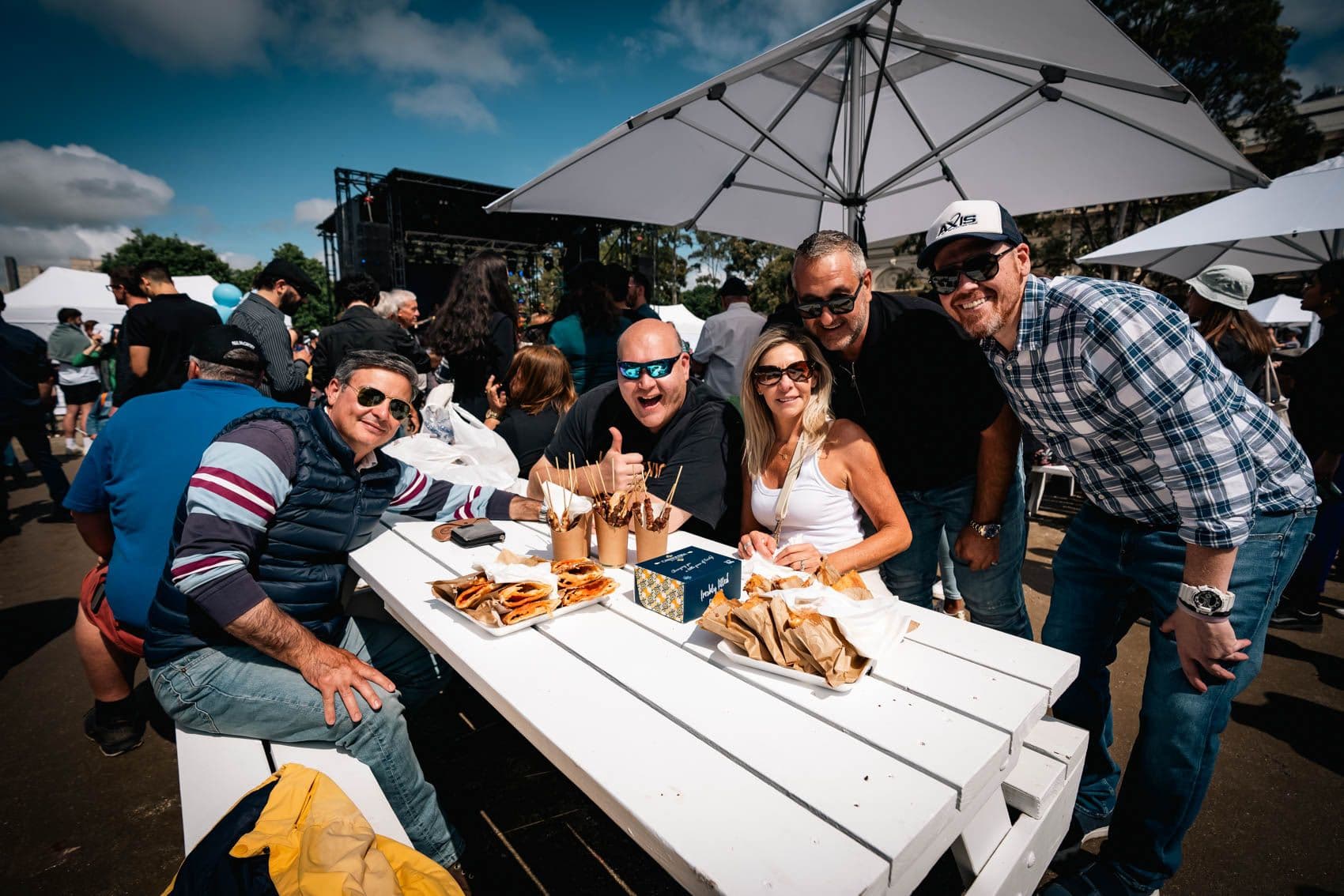 Guests enjoying food and drinks at a festival table