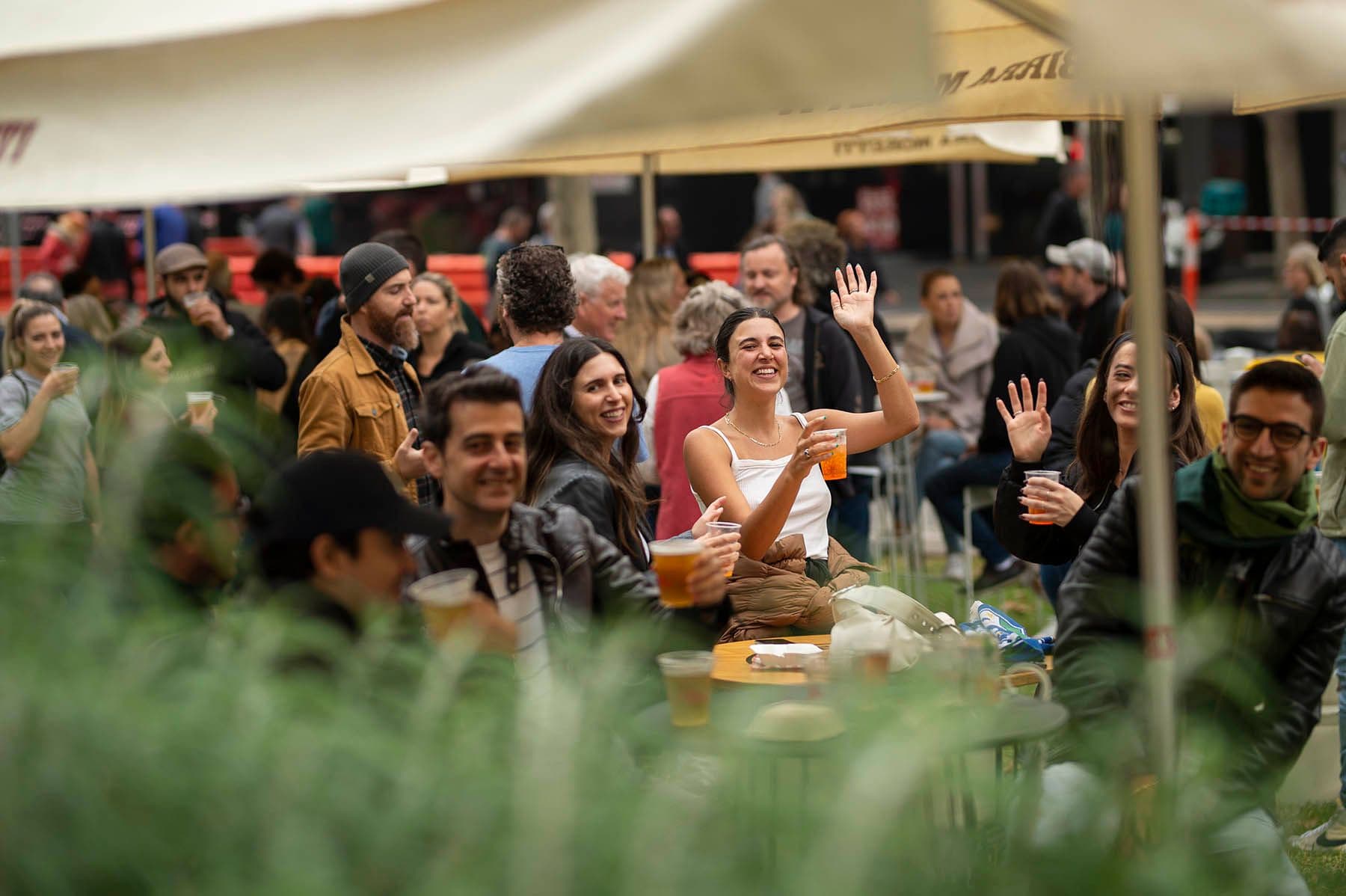 Crowd chatting and drinking at an outdoor festival