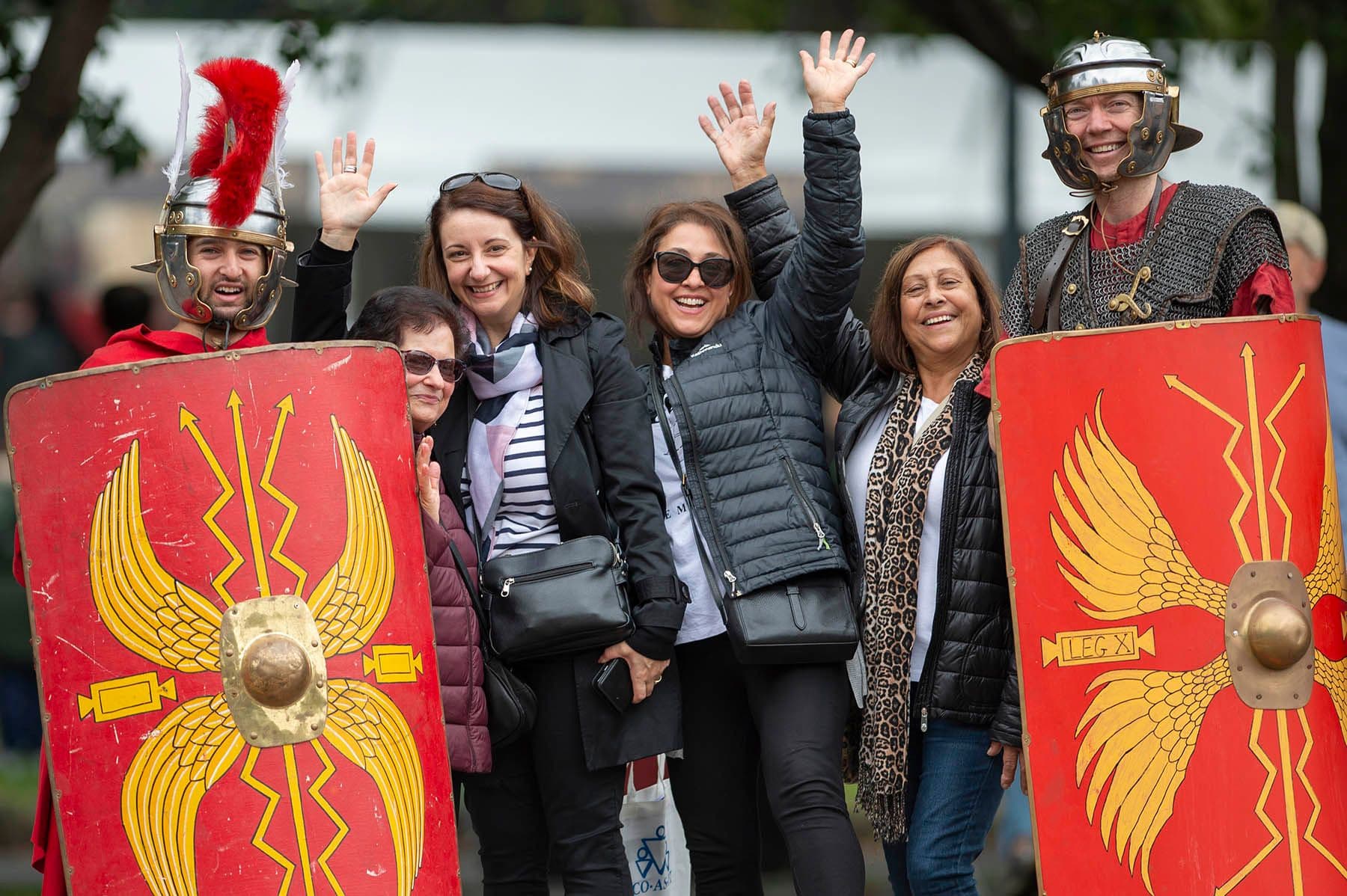 Roman legionnaires and festivalgoers pose together with decorative red shields at Melbourne Italian Festa