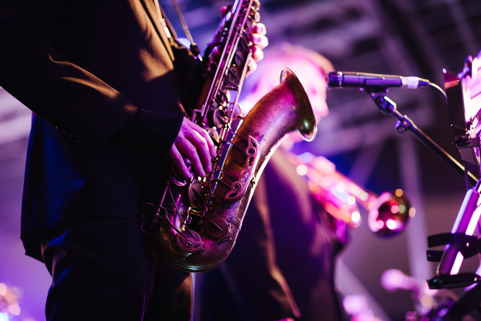Saxophonist performing under stage lighting