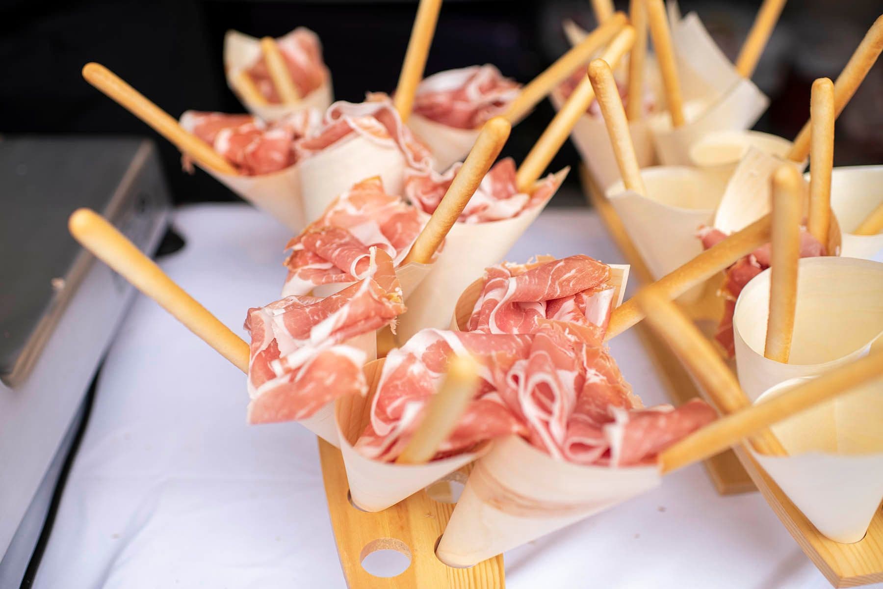 Italian cured meats and breadsticks on wooden serving boards
